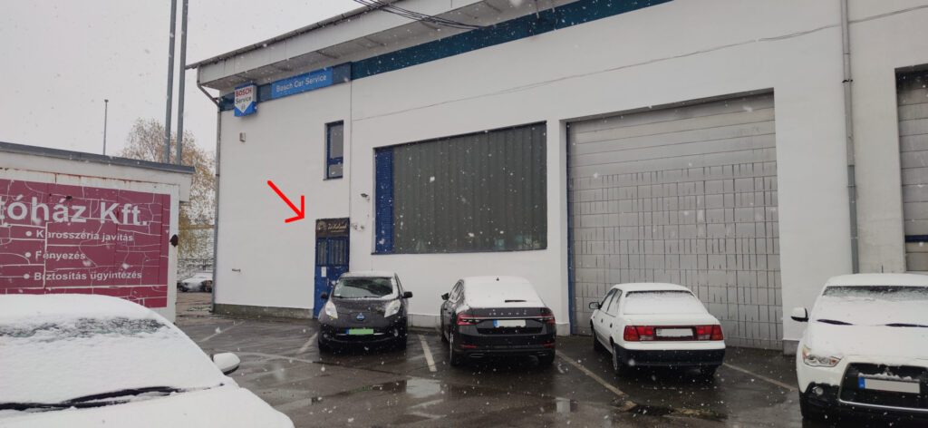 Fehér épület, előtte autók állnak.